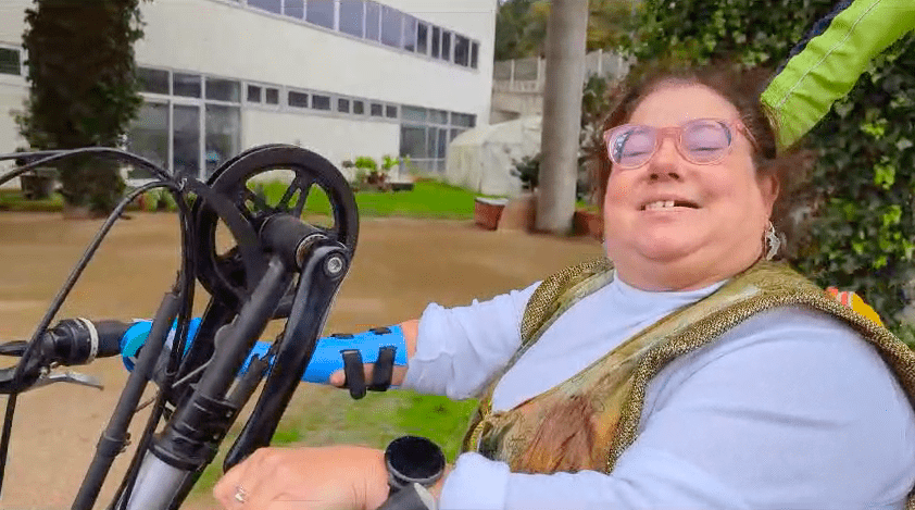 Rosa with her prosthesis adapted by Ayúdame for her handbike