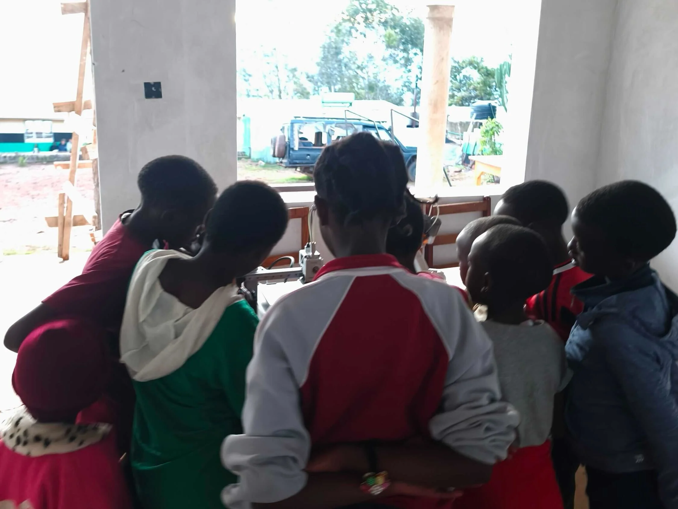 Niños alrededor de la impresora del 3DLab en Kenia